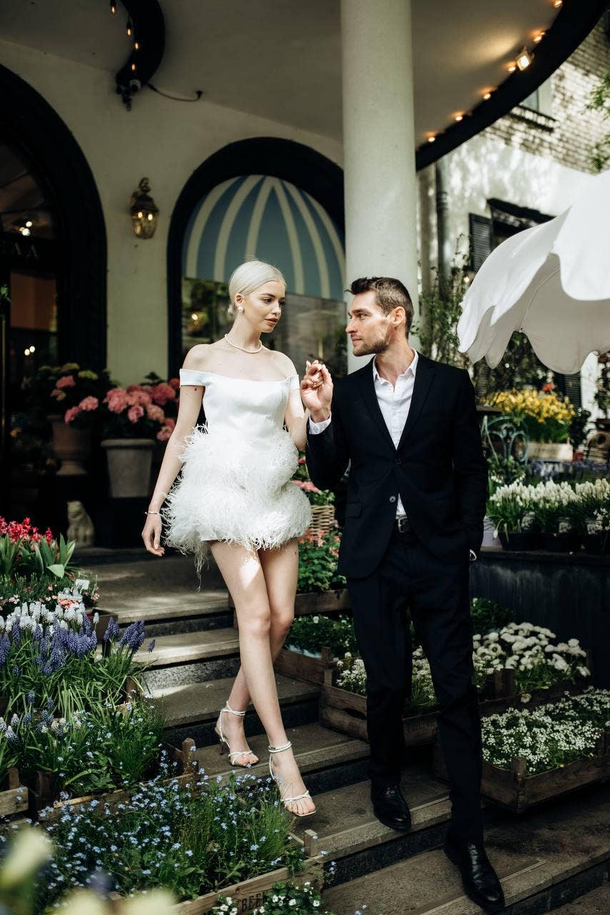 White bridal off-shoulder mini dress with structured satin bodice & soft voluminous feather skirt, short wedding gown