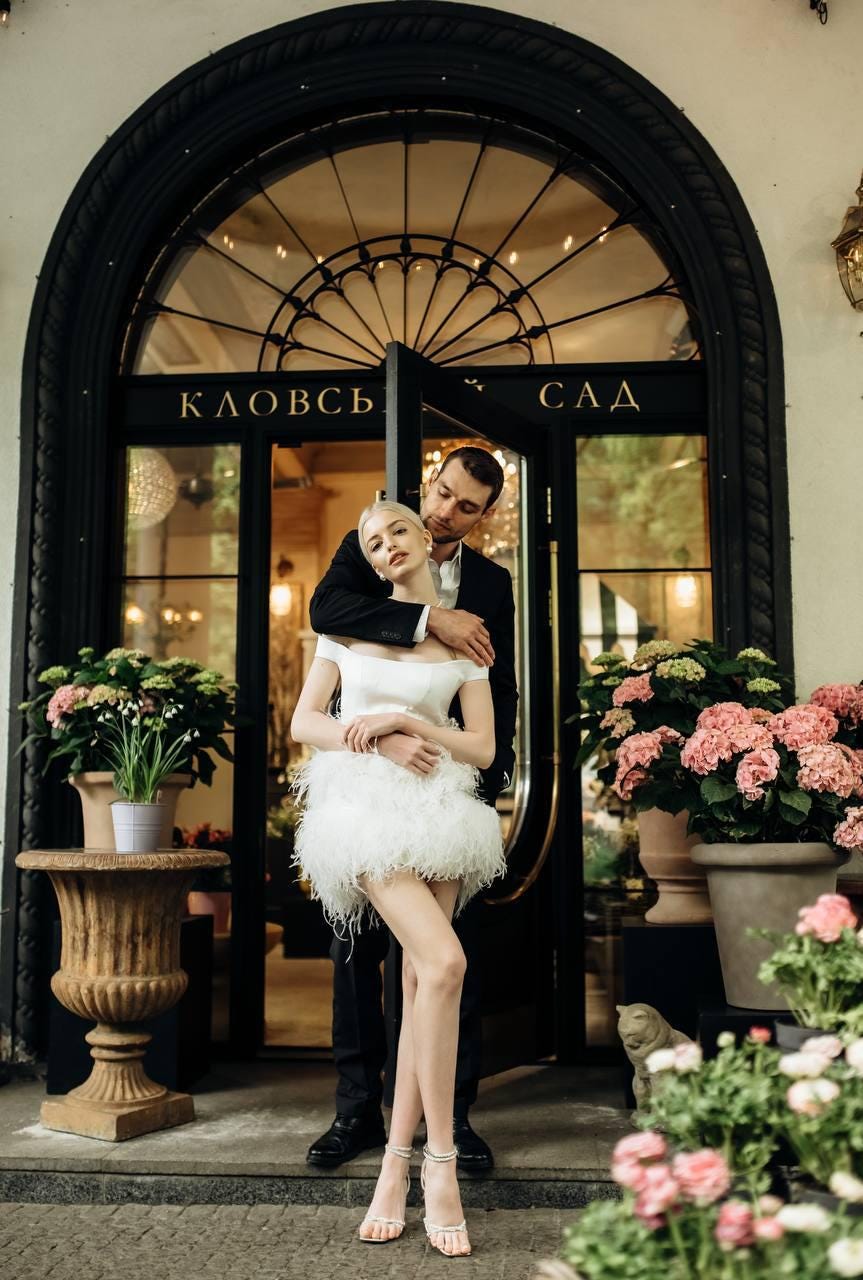 White bridal off-shoulder mini dress with structured satin bodice & soft voluminous feather skirt, short wedding gown