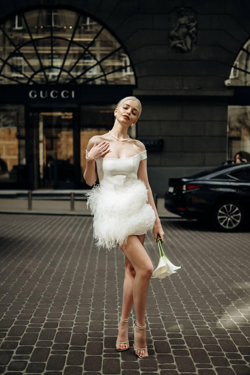 White bridal off-shoulder mini dress with structured satin bodice & soft voluminous feather skirt, short wedding gown